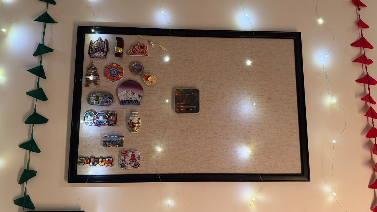 Magnetic wall board adorned with warm fairy lights and mountain trekking souvenir magnets