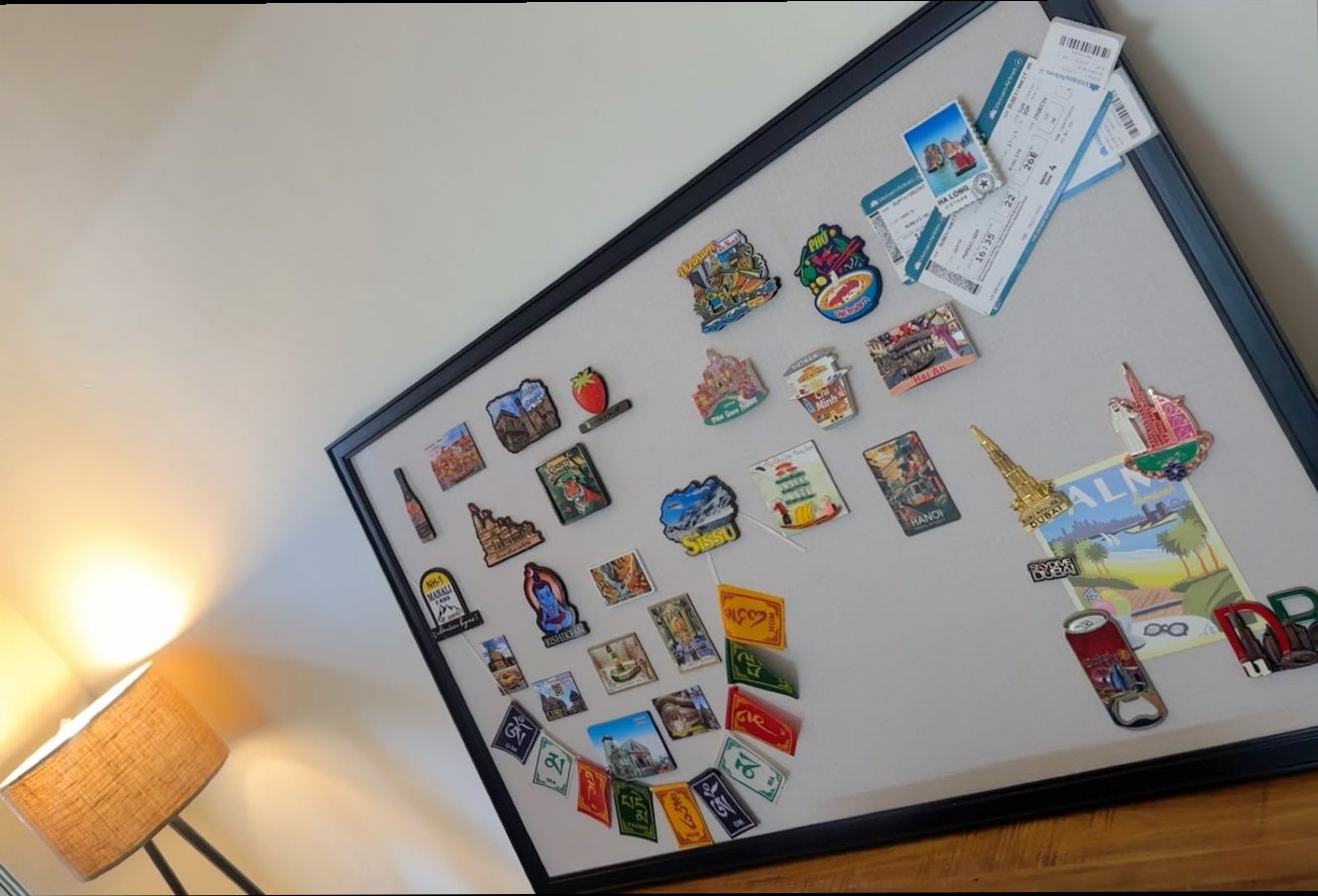 Warm bedroom lamp corner displaying magnetic travel board with festival flags